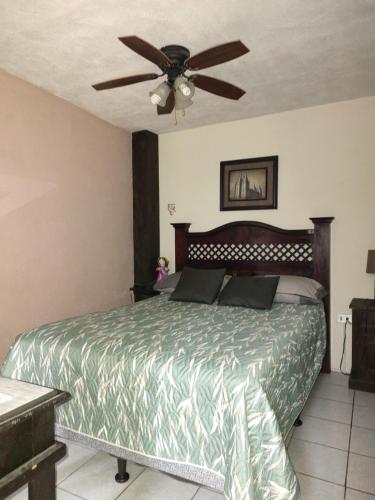 - une chambre avec un lit et un ventilateur de plafond dans l'établissement Loft aeropuerto, à Guatemala