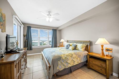 Dormitorio con cama, escritorio y TV en Navy Cove 1405 en Gulf Shores
