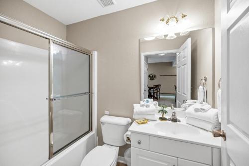 y baño con aseo, lavabo y espejo. en Navy Cove 1405 en Gulf Shores