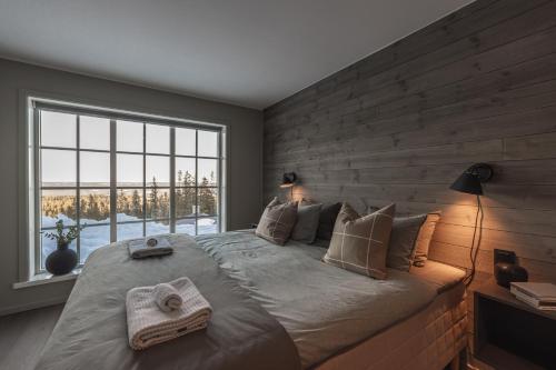 a bedroom with a large bed and a large window at Fjällparadiset Lindvallen in Sälen