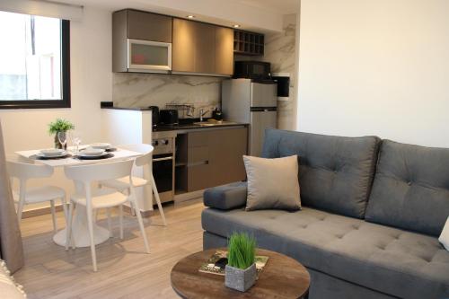 a living room with a couch and a table and a kitchen at In House BA - Le coq in Buenos Aires