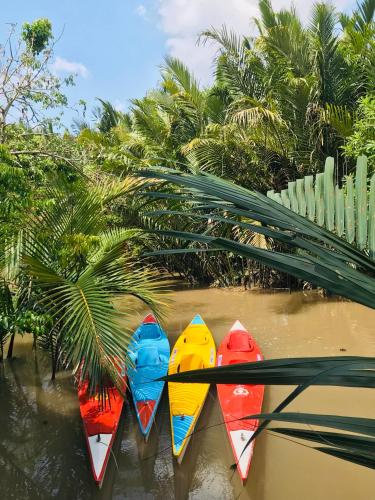a group of kayaks are lined up in the water at Ba Danh Homestay & Kitchen - Ben Tre Mekong in Ben Tre