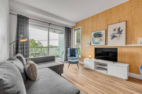 a living room with a couch and a television at Initial / Artsy / Centre ville de Quebec in Quebec City