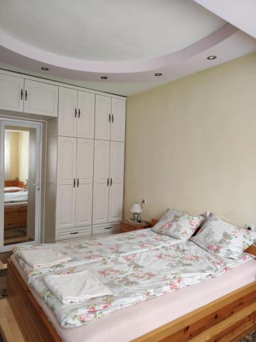 a bedroom with a large bed with white cabinets at Family Hotel Velevi in Velingrad
