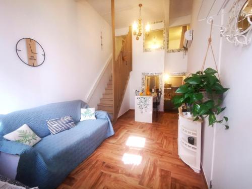uma sala de estar com um sofá azul e uma escada em Charming Portuguese style apartment, for rent "Vida à Portuguesa", "Fruta or Polvo" Alojamento Local em Portimão