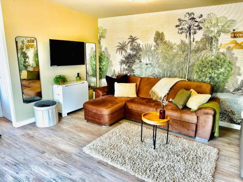 a living room with a couch and a tv at Log Cabin near Bath in Chippenham