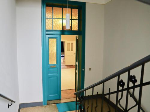 einen Flur mit blauer Tür und einer Treppe in der Unterkunft Residenz am Dresdner Stadtwald in Dresden