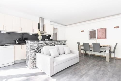 un salon avec un canapé blanc et une table dans l'établissement Apartment with balcony next to Buttes Chaumonts, à Paris