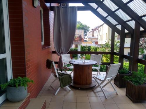 a patio with a table and chairs and a window at Apartament LOFT in Ostróda