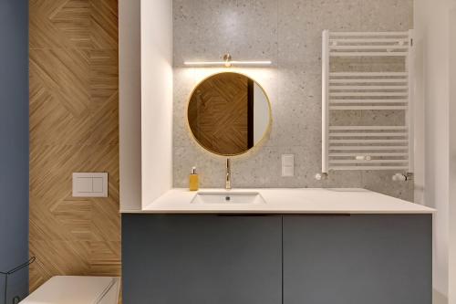 a bathroom with a sink and a mirror at GRANO FLATS Sobieszewo - Baltic Line in Gdańsk