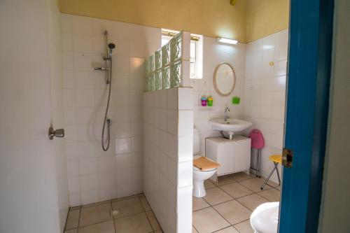 uma casa de banho com um chuveiro, um WC e um lavatório. em 26 Casa Chibi Chibi em Kralendijk