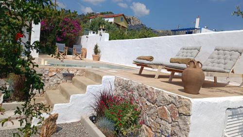 un jardin avec un banc et un mur en pierre dans l'établissement Ktima Natura, à Archangelos
