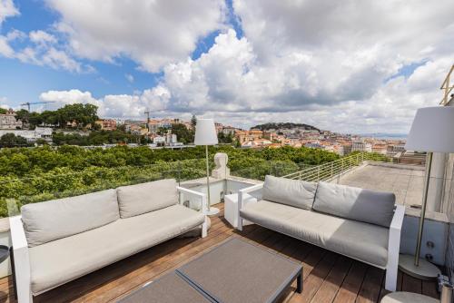 a balcony with two white couches and a view at Liberdade Elegance W/Rooftop Pool by LovelyStay in Lisbon