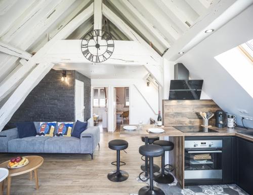 Il comprend une cuisine et un salon doté d'un canapé bleu. dans l'établissement Le Rooftop - vue Cathédrale - Climatisation, à Troyes