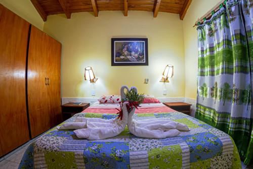 two swans are sitting on top of a bed at Cabañas El Refugio del Mensu in Puerto Iguazú