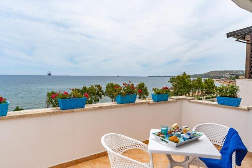 a table and chairs on a balcony with a view of the ocean at Almaré B&B in Crotone