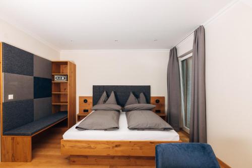 a bedroom with a bed and a blue chair at Gasthof Nindler in Steindorf am Ossiacher See
