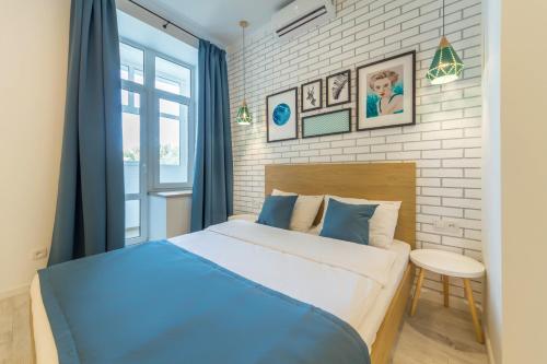 a bedroom with a blue bed and a brick wall at Idea Design Apart-Hotel in Kyiv
