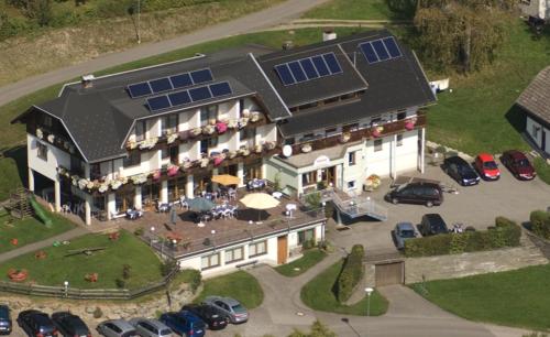 eine Luftansicht eines großen Hauses mit Sonnenkollektoren darauf in der Unterkunft Gasthof Nindler in Steindorf am Ossiacher See