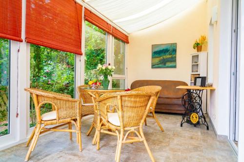 - une terrasse couverte avec une table, des chaises et un canapé dans l'établissement Feriendomizil Wiesenhaus, à Zingst