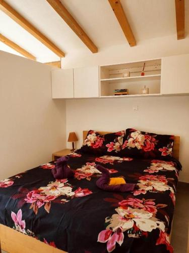 a bedroom with a bed with a black blanket with flowers at Valle Verde in Vinkuran