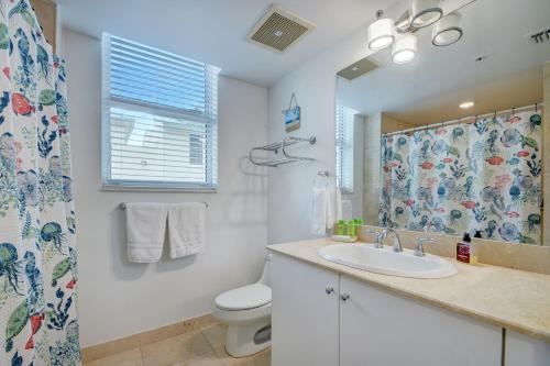 a bathroom with a sink and a toilet and a mirror at One Bedroom In Amazing Condobeach Pass Included! in Boynton Beach