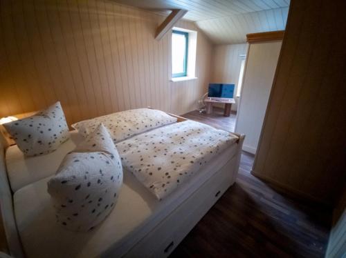- une chambre avec un lit blanc avec des oreillers et une fenêtre dans l'établissement Spreewälder Schwalbenhof - Ferienwohnung "Storchennest", à Golßen