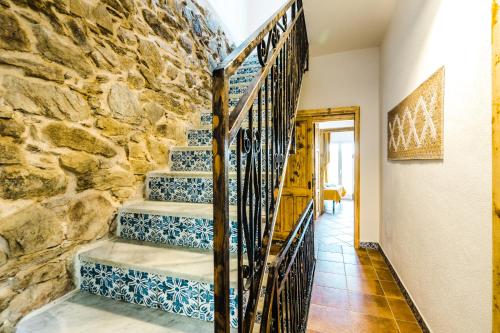 a staircase in a house with blue and white tiles at CAMERA VISTA MARE CASA RAIMONDA Ammentos Posada in Posada