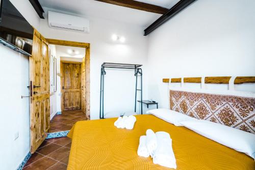 um quarto com uma cama amarela com toalhas em CAMERA VISTA MARE CASA RAIMONDA Ammentos Posada em Posada