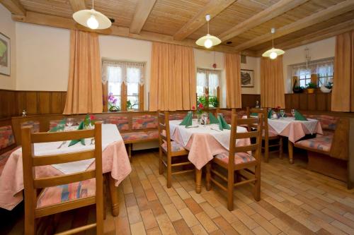 ein Esszimmer mit Tischen und Stühlen in einem Restaurant in der Unterkunft Gasthof Forststube in Velden am Wörthersee