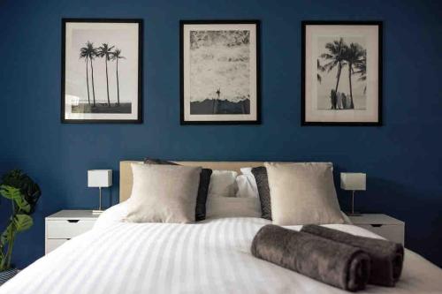 a bedroom with blue walls and a large white bed at Braunton Beach Boutique in Wrafton
