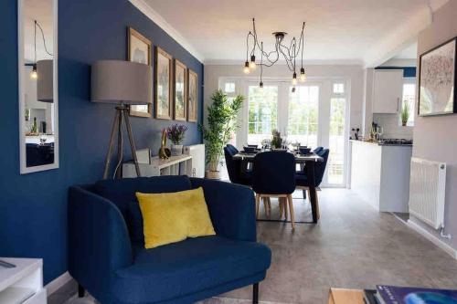 a blue living room with a blue couch and a dining room at Braunton Beach Boutique in Wrafton