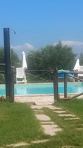 una piscina con mesa y sillas junto a ella en APPARTAMENTO FONTEBELLA en Montemarciano