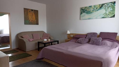 a bedroom with a purple bed and a chair at DAZ Dunai Apartman Zalakros in Zalakaros
