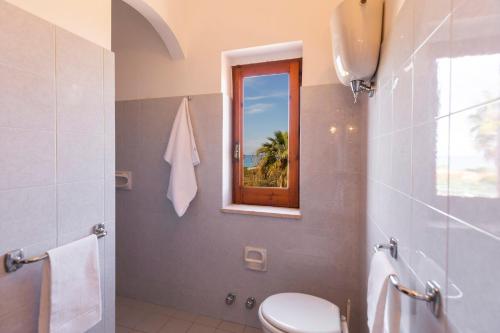 San NicolòにあるResidence Limonetoのバスルーム(トイレ付)、窓が備わります。