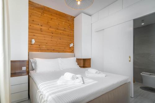 a bedroom with a white bed with towels on it at Thea Eco Suites in Nea Kallikrateia