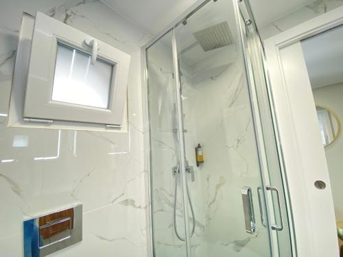 een badkamer met een douche en een glazen deur bij Canto Doce Troino II in Setúbal
