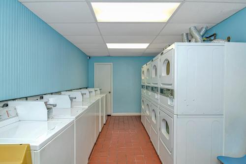 a bathroom with white washing machines and blue walls at Sand Dunes 2740 in Myrtle Beach