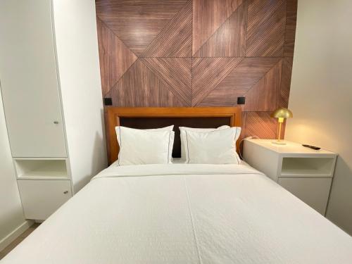 1 dormitorio con 1 cama blanca grande y cabecero de madera en Canto Doce Troino II en Setúbal