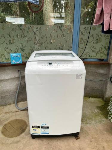 eine weiße Waschmaschine vor einem Fenster in der Unterkunft Akerama farm stay in Hukerenui