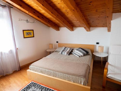 a bedroom with a bed in a room with wooden ceilings at Casa Celesta in Aosta