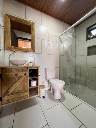 a bathroom with a toilet and a sink and a shower at Pousada Costaneira in Cambará