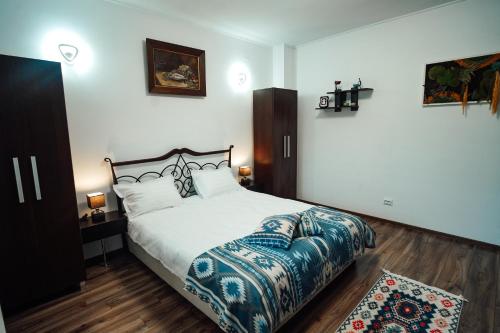 a bedroom with a bed with a blue and white bedspread at Casa cu Elefanți in Corbşori