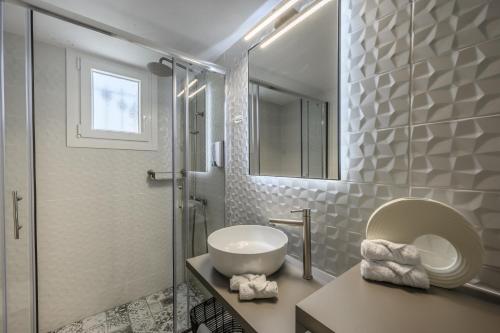 a white bathroom with a sink and a mirror at VICANTI Luxury Apartments in Pylos
