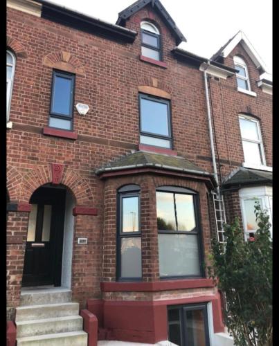 a red brick house with a staircase in front of it at Eccles in Manchester