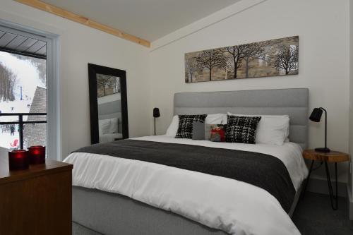a bedroom with a large bed and a window at Destination Owl's Head - Mtn Haus in Mansonville
