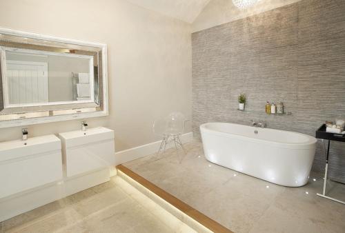 a bathroom with a white tub and a mirror at The Potting Shed in Shifnal