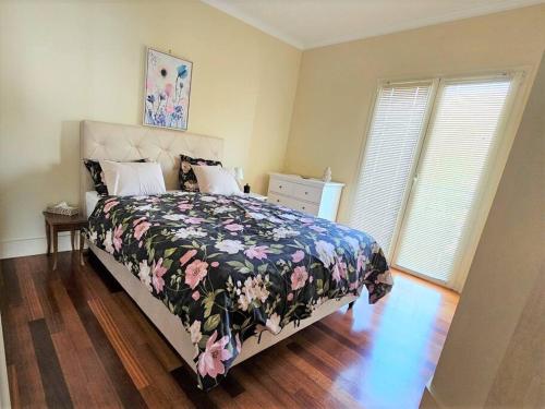 - une chambre avec un lit doté d'un couvre-lit floral et 2 fenêtres dans l'établissement Villa Alba, Apartment Katja - with swimming pool, à Ičići