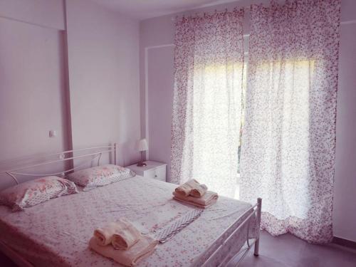 a bedroom with a bed with two towels on it at Melistalia apartment 2 in Néa Michanióna