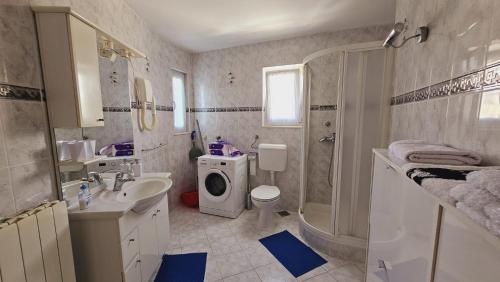 ein Badezimmer mit Waschbecken und Waschmaschine in der Unterkunft Apartment house Berry in Primošten